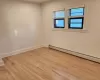 Empty room featuring light hardwood / wood-style floors and a baseboard radiator