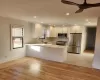 Kitchen featuring premium appliances, kitchen peninsula, light wood-type flooring, and white cabinetry