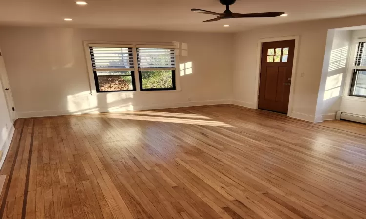 Foyer entrance with baseboard heating, ceiling fan, and light hardwood / wood-style flooring