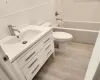 Bathroom featuring tile walls, toilet, decorative backsplash, and vanity