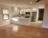 Kitchen featuring white cabinets, stainless steel appliances, light hardwood / wood-style flooring, and kitchen peninsula