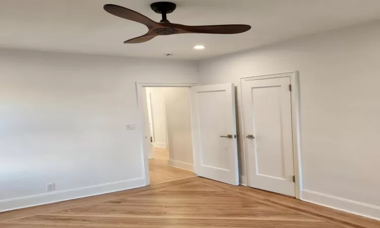 Unfurnished bedroom with ceiling fan and light hardwood / wood-style floors