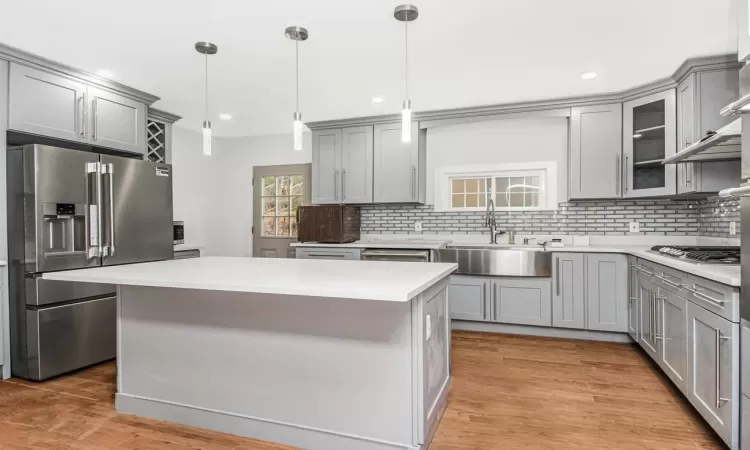 Kitchen with sink, a center island, pendant lighting, gray cabinetry, and appliances with stainless steel finishes