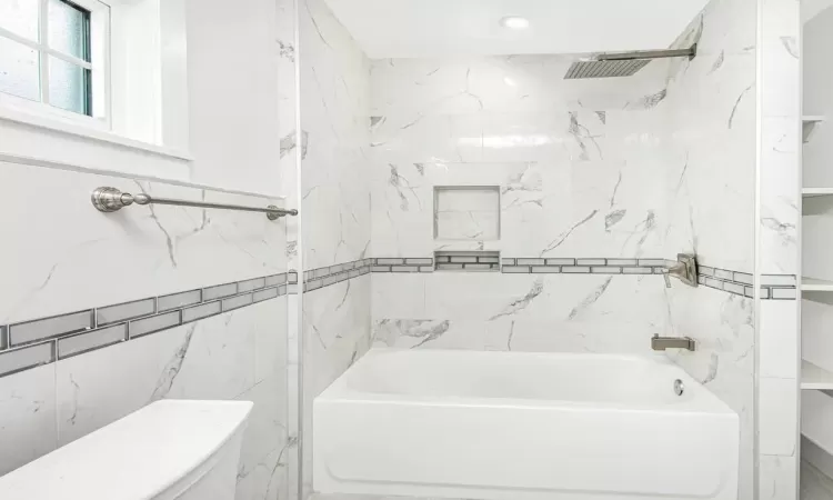 Bathroom featuring toilet and tiled shower / bath combo