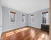 Spare room featuring radiator and wood-type flooring