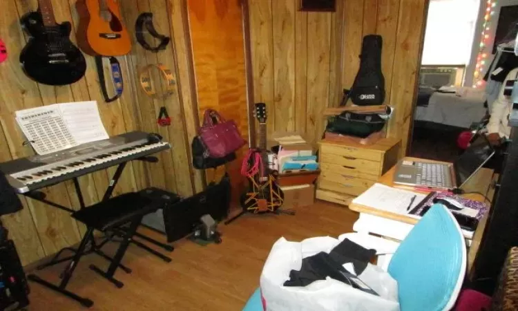 Miscellaneous room with wood-type flooring, wood walls, and cooling unit