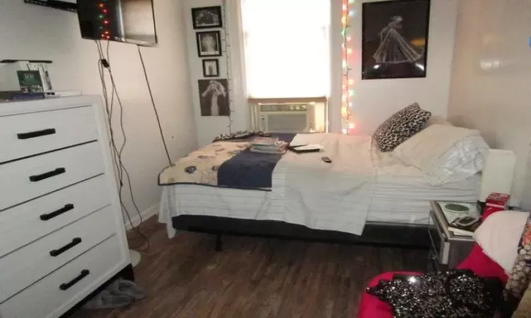 Bedroom with dark wood-type flooring and cooling unit