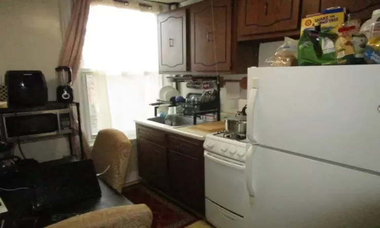 Kitchen featuring sink and white appliances