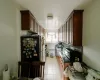 Kitchen with stainless steel appliances, light tile patterned floors, radiator, and dark brown cabinets