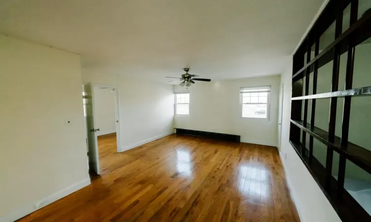 Spare room with wood-type flooring and ceiling fan