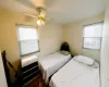 Bedroom with multiple windows, ceiling fan, and dark hardwood / wood-style floors