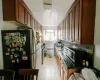 Kitchen with stainless steel appliances, decorative backsplash, radiator heating unit, and light tile patterned floors