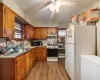 Kitchen with range, white fridge, tasteful backsplash, a baseboard heating unit, and light wood-type flooring