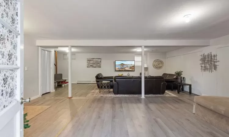 Living room featuring a baseboard heating unit and light wood-type flooring