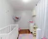 Bedroom featuring dark wood-type flooring and a crib