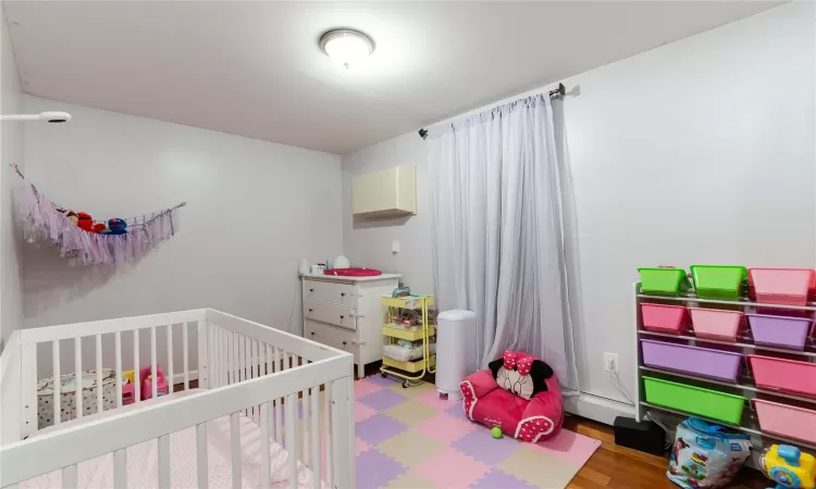 Bedroom featuring a crib and hardwood / wood-style flooring