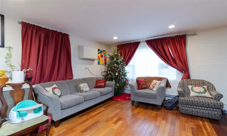 Living room featuring a baseboard heating unit and hardwood / wood-style flooring