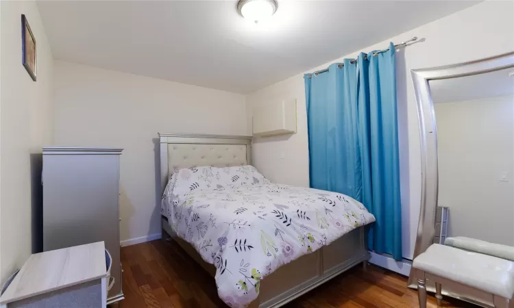 Bedroom with dark hardwood / wood-style floors