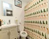 Bathroom with vanity, toilet, decorative backsplash, and tile walls