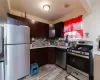 Kitchen featuring stainless steel appliances, sink, light hardwood / wood-style flooring, decorative backsplash, and dark brown cabinets