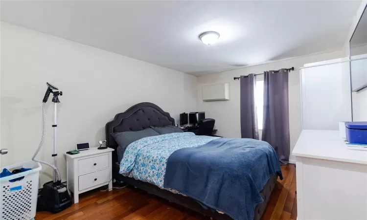 Bedroom with dark hardwood / wood-style flooring