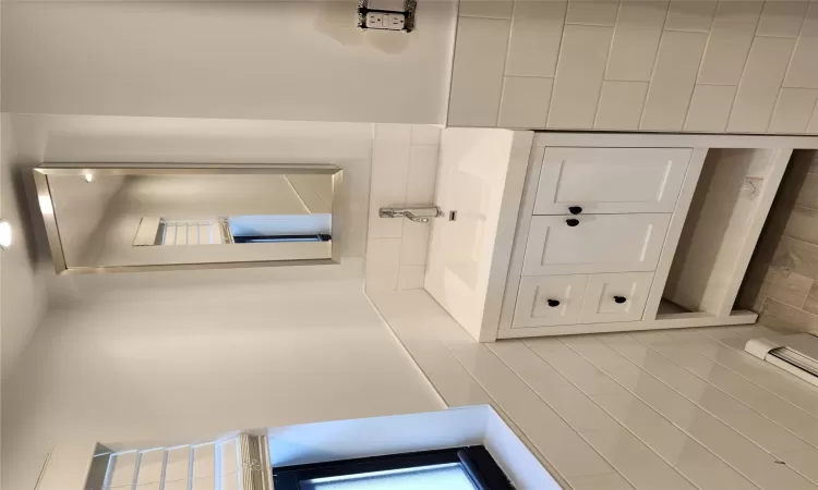 Bathroom with tile walls, a baseboard radiator, and vanity