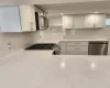 Kitchen featuring stainless steel appliances, white cabinetry, and decorative backsplash