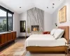 Bedroom featuring a wood burning marble slab fireplace and vaulted ceiling