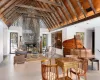 Living room featuring high vaulted ceiling, a fireplace, wood ceiling, and beamed ceiling