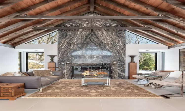 Italian tiled radiant floor, marble slab fireplace, high vaulted ceiling, wooden ceiling, and beamed ceiling