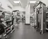 Exercise room with a paneled ceiling and an AC wall unit