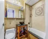 Full bathroom featuring toilet, shower / tub combo, tile walls, and sink