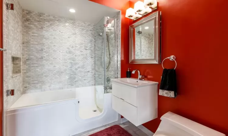 Full bathroom featuring toilet, tiled shower / bath, and vanity