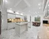 Kitchen with a kitchen island, white cabinetry, range, and light stone counters