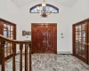 Entrance foyer with french doors, a baseboard radiator, an inviting chandelier, and high vaulted ceiling