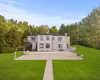 Rear view of house with a lawn, french doors, a balcony, and a patio