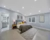 Bedroom with lofted ceiling, light wood-type flooring, and connected bathroom