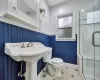 Bathroom with tile patterned flooring, a shower with shower door, and toilet