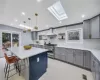 Kitchen with wall chimney exhaust hood, range with two ovens, decorative backsplash, and decorative light fixtures