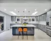 Kitchen with a skylight, tasteful backsplash, stainless steel refrigerator with ice dispenser, pendant lighting, and a kitchen island