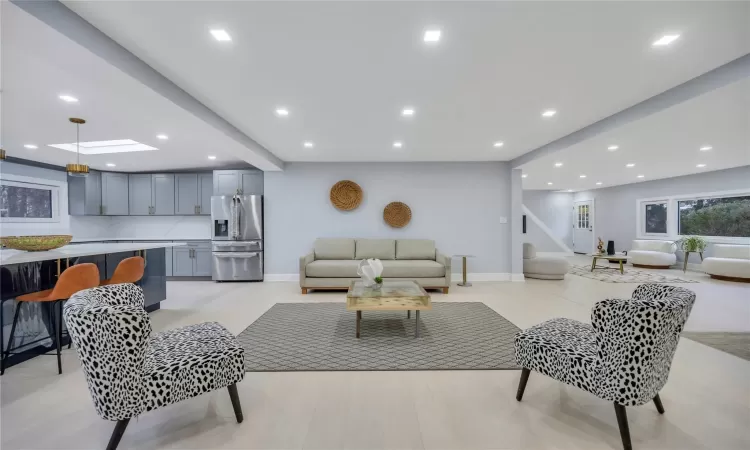 Living room featuring a skylight and light hardwood / wood-style flooring