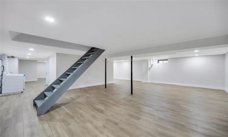 Basement featuring washing machine and dryer and light hardwood / wood-style floors