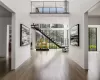 Foyer featuring a wall of windows with sun drenched light, and custom steel spine staircase