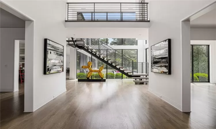 Foyer featuring a wall of windows with sun drenched light, and custom steel spine staircase