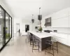 Kitchen featuring , a large center island and dining area flowing in to the family room with fireplace and with sliding glass doors to the pool and patio