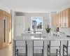 Kitchen with sink, kitchen peninsula, light brown cabinetry, and a breakfast bar area