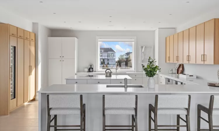 Kitchen with sink, kitchen peninsula, light brown cabinetry, and a breakfast bar area