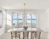 Dining room featuring a notable chandelier, a water view, and plenty of natural light