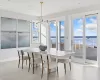 Tiled dining area featuring a notable chandelier and a water view