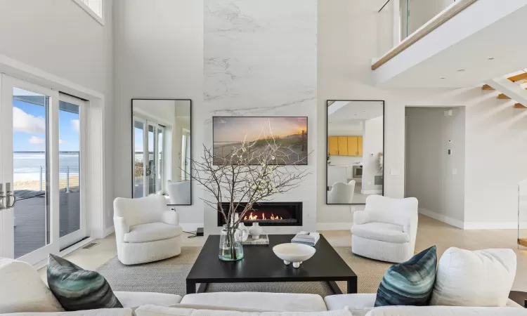 Living room featuring a high ceiling, a premium fireplace, and a healthy amount of sunlight